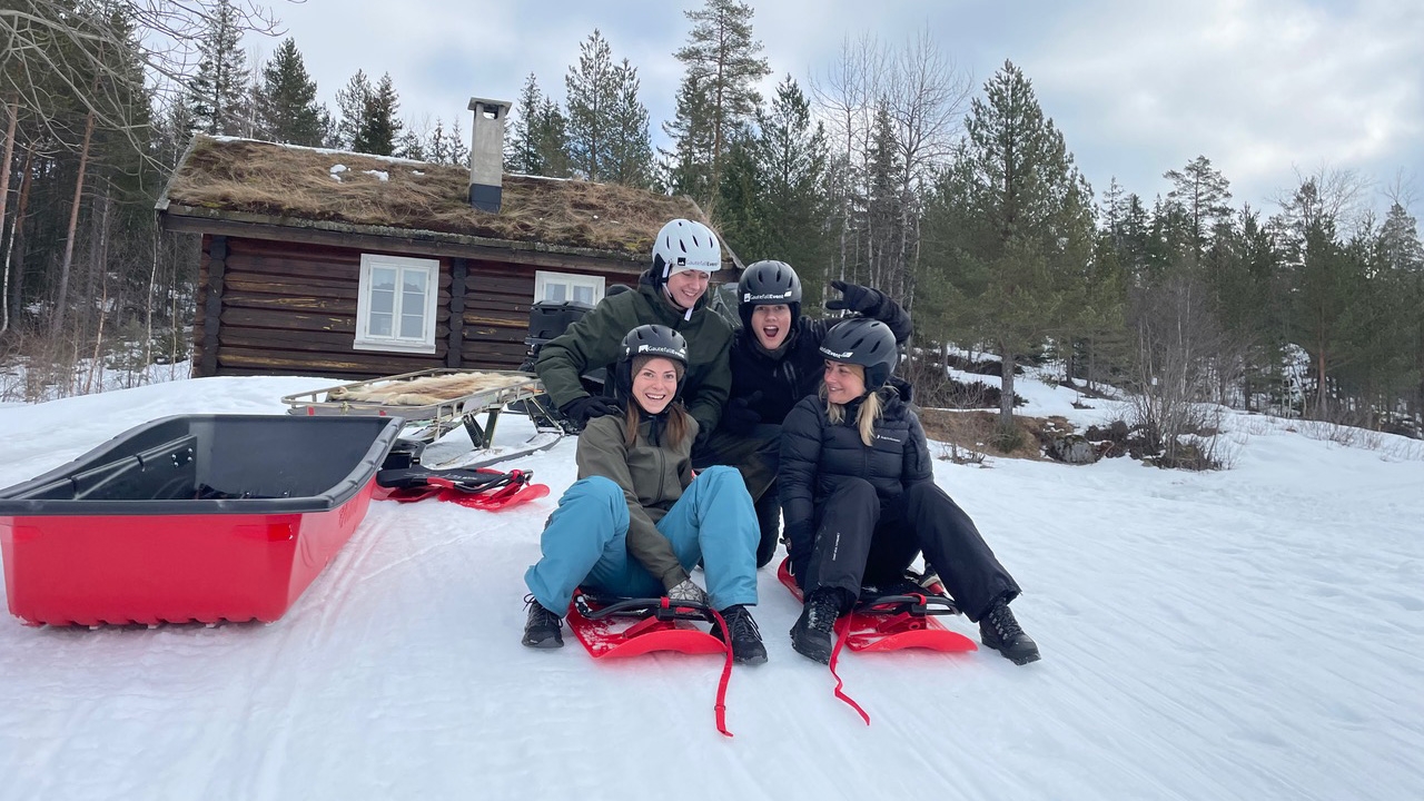 En familj som testar en snowbob.